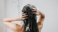 Woman washing hair with shampoo and shower in bathroom, Asian female body and hair care with foam to freshness. Spa and Health care.