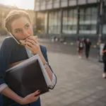 Busy woman is in a hurry, she does not have time, she is going to eat snack on the go. Worker eating, drinking coffee, talking on the phone, at the same time. Businesswoman doing multiple tasks. Multitasking business person.