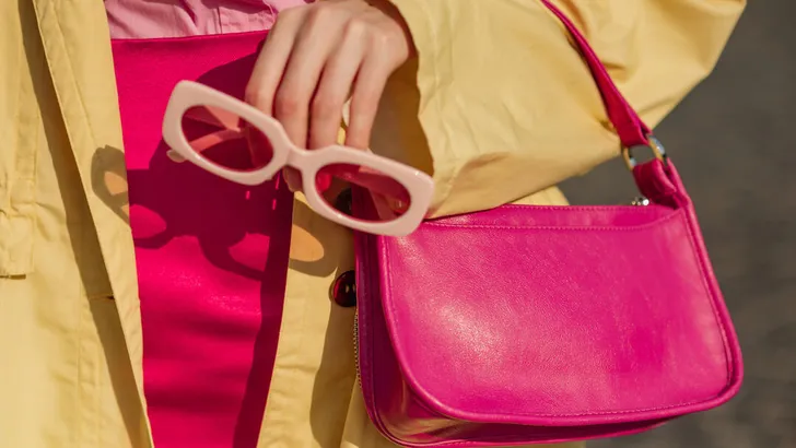 Close up trendy spring fashion outfit with pink, fuchsia color faux leather mini bag, sunglasses
