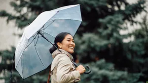 Blue Monday vrolijk doorkomen – Foto van stijlvolle vrouw lachend met doorzichtige paraplu