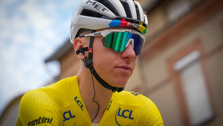Tadej Pogacar met een neutrale blik in de gele trui en met regenbooghelm tijdens de Tour de France.