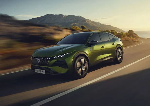 Groene Peugeot 408 rijdt over een kustweg
