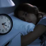 Depressed young woman lying in bed cannot sleep from insomnia. S