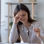 Tired woman rubbing eyes feeling fatigue from glasses computer work