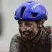 Lucinda Brand zit onder de modder tijdens een zware veldrit, met een vermoeide blik onder haar blauwe Trek-helm.