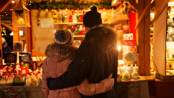 happy senior couple hugging at christmas market