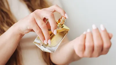 Vrouw houdt flacon vast en spuit flacon op haar pols