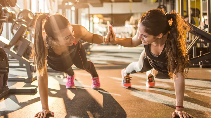 twee vrouwen sporten samen en geven elkaar een high five