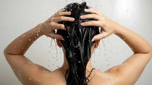 De fout die bijna iedereen met vet haar maakt onder de douche