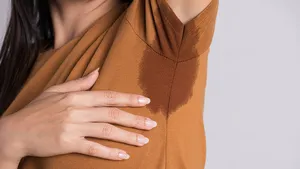 Vrouw met zweetvlek onder oksels - zweetoksels