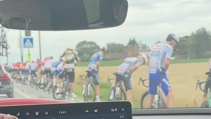 het peloton in de tour doet een plas