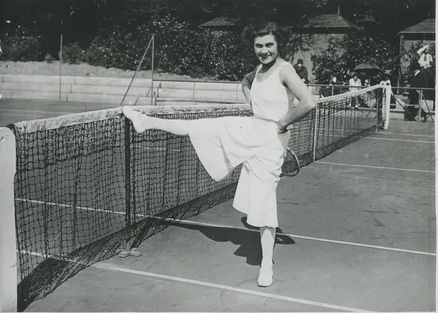 Lili de Alvarez tijdens een tenniswedstrijd in een witte broek
