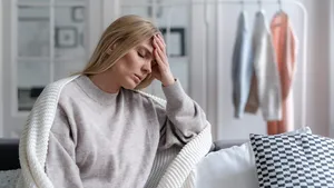 worried blonde woman with headache and fever