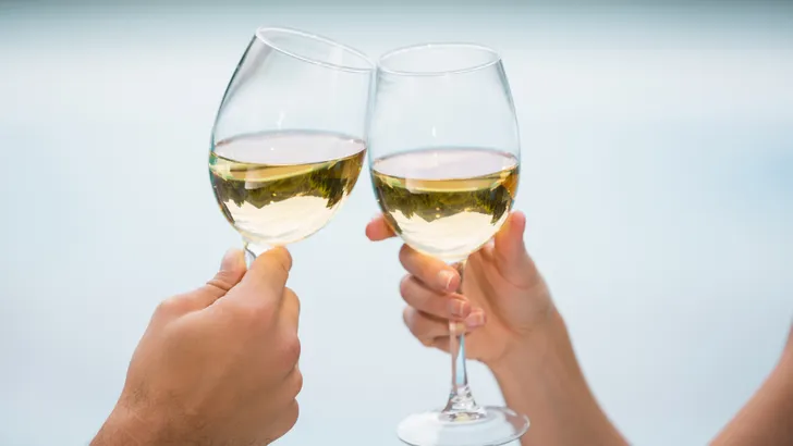 Twee glazen proosten met witte wijn
