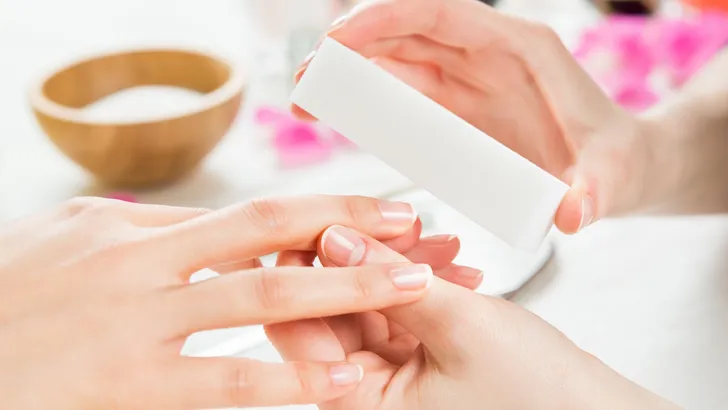 Manicure with buffer at nail salon