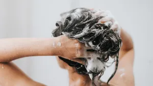 Vrouw wast haar haar volgens Abbey Yung methode en neemt een douche in de badkamer.