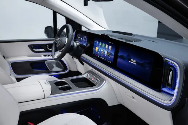 Luxe interieur van de Mercedes VLE met breed digitaal dashboard, witte stoelen, blauwe sfeerverlichting en groot infotainmentscherm.