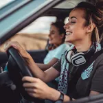 Twin sisters driving car and enjoying road trip
