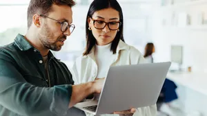 Design professionals using a laptop together in an office