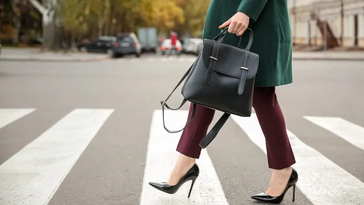 Beautiful fashionable woman crossing road