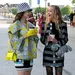 Twee vriendinnen lachend op straat met koffie - geluksdag booschutter