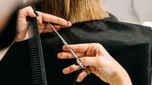 Process of hair cutting at a beauty salon, using scissors. Hair