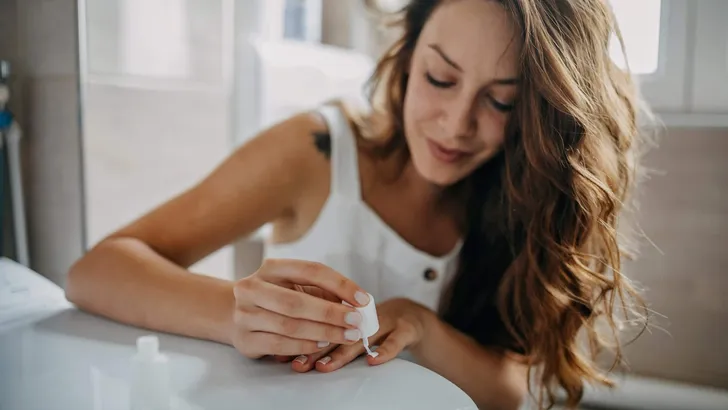 Young woman paints her nails