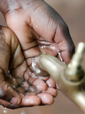 Kinderhandjes onder waterkraan