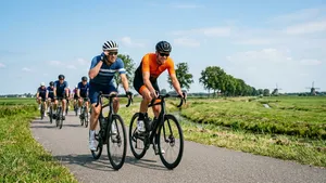 Een gefrustreerde mannelijke wielrenner kijkt opzij naar een halfwheeler tijdens een groepsrit op de racefiets.
