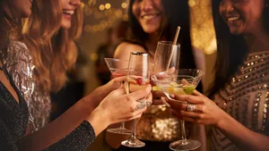 Drie snacks om te vermijden voor een gladde huid. – Foto van vier vrouwen met cocktails in hand.