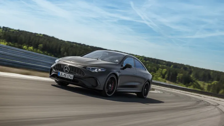 De matgrijze Mercedes-AMG CLA 45 4MATIC+ rijdt over een circuit, driekwart vooraanzicht met zicht op de AMG-grille.