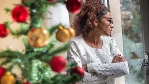 Pensive young black woman celebrating Christmas alone