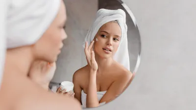 Vrouw doet haar skincare in de badkamer