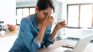 Vrouw zit achter bureau maar wil stress verminderen