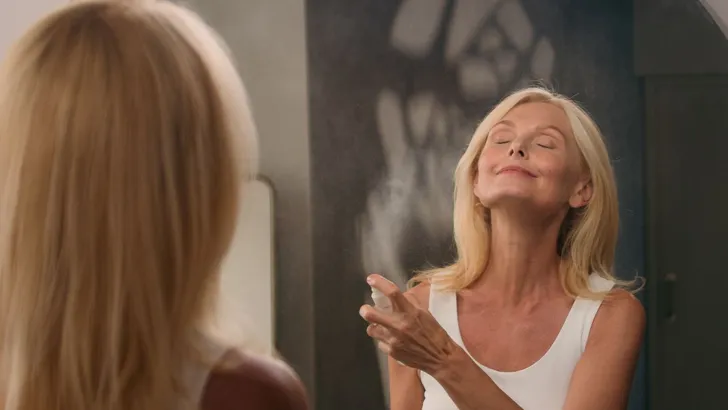 Een vrouw die parfum opspuit