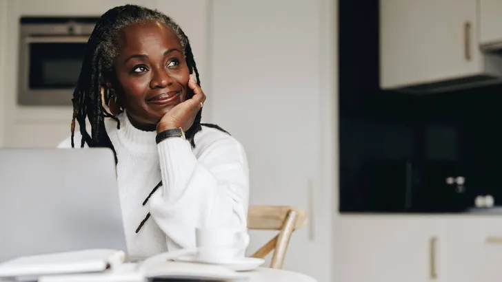 Mature businesswoman looking away thoughtfully in her home office