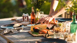 Man taking a slice of cheese at midsummer dinner