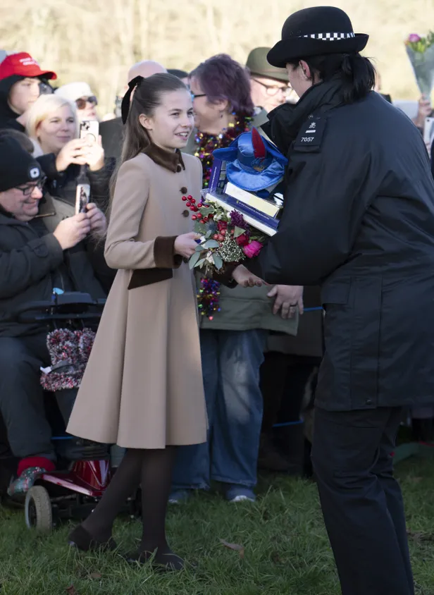 Prinses Charlotte groet het publiek bij de kerstwandeling te Sandringham.