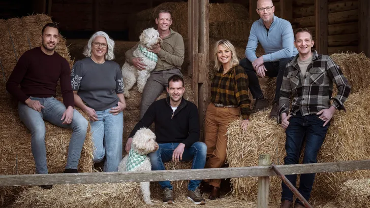 Yvon Jaspers en de boeren van nieuw seizoen Boer Zoekt Vrouw op strobalen in schuur.