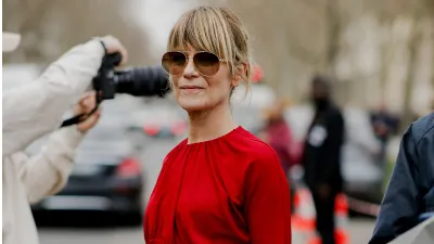 Vrouw in rode jurk en bruine zonnebril gespot op straat tijdens fashion week