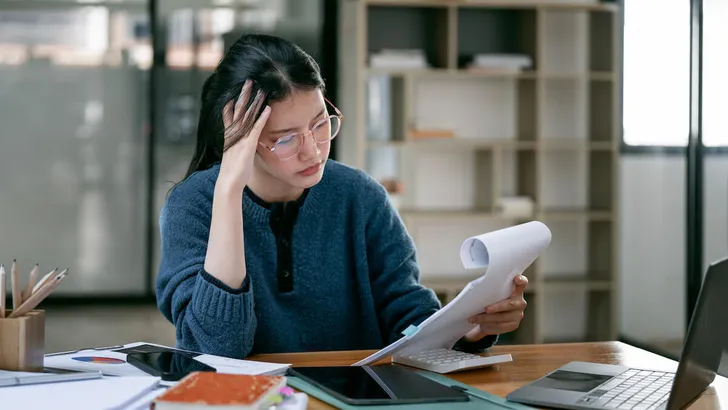 Asian women are stressed while working at document in hand, Tired asian businesswoman with headache at office, feeling sick at work.