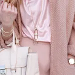 Young beautiful stylish woman walking in a pink coat, holding a bag in hands, street style, spring autumn trend, light pants