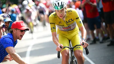 Tadej Pogacar klimt staand op zijn racefiets en toont een duidelijk asymmetrische fietshouding in zijn kniebeweging.