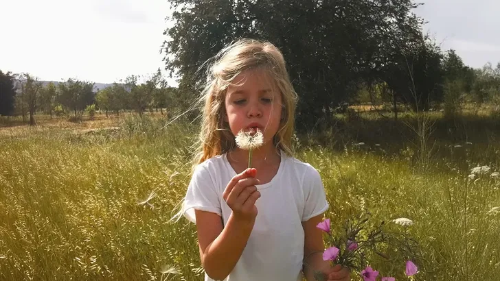 Roxy Dekker als jong meisje blaast tegen een paardenbloem - lyrics quiz Casual