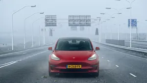 Ter illustratie: Een moderne rode Tesla rijdt over een verder compleet lege en snelweg op een autoloze zondag