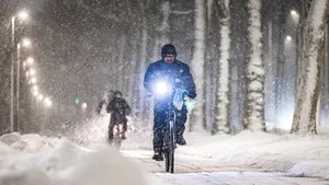 Een fietser trotseert een sneeuwbui tijdens code oranje. In het hele land geldt code oranje voor sneeuw en gladheid.