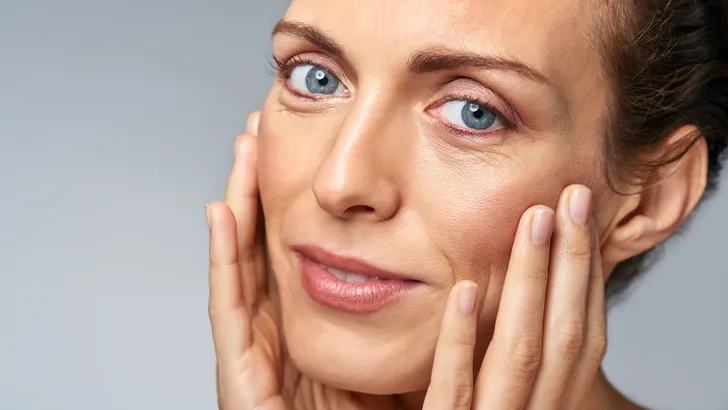 Vrouw met gevoede huid door crème op gezicht om droogtelijntjes en vochttekort in de winter te verminderen.