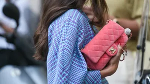 Weekendtips voor Pasen 2025. – Streetstyle-foto van vrouw in blauwe blouse met roze Chanel-tas.