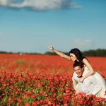 happy couple having fun in a field of poppies