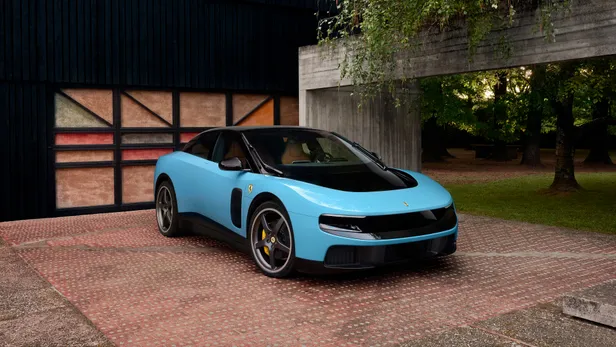 Blauwe Ferrari Luce schuin van voren bij een modern gebouw